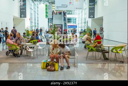 PHOTOKINA, KÖLN - 19. SEPTEMBER 2014: Menschen besuchen die Photokina in Köln. Sie posieren für kostenlose Aufnahmen für Besucher, um die neuen Kameras zu testen Stockfoto