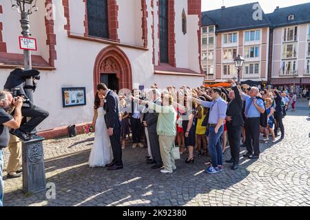 FRANKFURT, DEUTSCHLAND - 9. AUG 2014: Ehepaar mit Familie posiert für ein Hochzeitsfoto vor der Frankfurter Nicolai-Kirche. Stockfoto