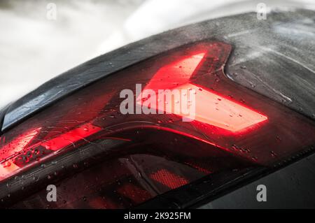 Nahaufnahme der modernen Luxus-Auto-Rückleuchten mit Wassertropfen bedeckt. Thema Fahrzeugbeleuchtung. Details Zum Fahrzeugdesign. Stockfoto