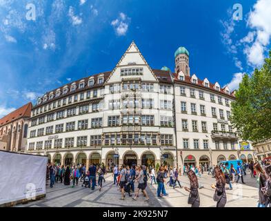 MÜNCHEN, 27. MAI 2016: Menschen in der Fußgängerzone mit Blick auf Hirmer, das größte Herrenmodehaus der Welt, mit Dekoration in M Stockfoto