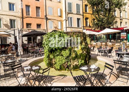 AIX EN PROVENCE, FRANKREICH - 19. AUG 2016: Die Leute genießen das Restaurant am zentralen Marktplatz mit einem von Moos bedeckten Brunnen. Stockfoto