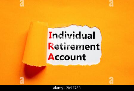 IRA-Symbol für individuelles Rentenkonto. Konzeptworte IRA individuelles Rentenkonto auf weißem Papier auf schönem orangenen Hintergrund. IRA für Unternehmen Stockfoto