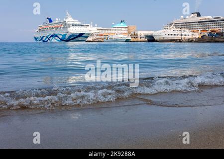 Rhodos, Griechenland - 23. August 2022: Panoramablick auf schöne Yachten, touristische Fähren stehen im Hafen von Rhodos, Griechenland. Stockfoto