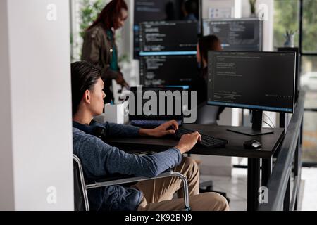 Asian deaktiviert Software developerr Eingabe Programmiersprache auf dem Computer, mit Big Data und Firewall-Server. Systemingenieur mit körperlicher Beeinträchtigung in einer invaliditätsfreundlichen IT-Agentur. Stockfoto