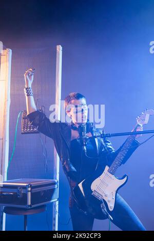 Verrücktes Rocker-Mädchen, das im Studio Live-Show aufführt, E-Gitarre spielt und Heavy Metal-Musik singt. Coole, funky Sängerin, die alternative Rockperformance mit Lederjacke und dunklem Make-up macht. Stockfoto