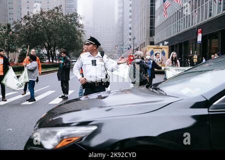 New York, Usa. 25. Oktober 2022. Polizeibeamte leiten den Verkehr, während Aktivisten die Park Avenue während der Demonstration blockieren. Umweltaktivisten mit Aussterben Rebellion blockieren den Verkehr auf der Park Avenue in New York Citys Midtown. In Erwartung des zehnjährigen Jubiläums des verheerenden Hurrikan Sandy schwor eine Koalition von Umweltgruppen, die Park Avenue zu schließen, um mutige und dringende Maßnahmen zur Eindämmung des Klimawandels zu fordern. Fünfzehn Aktivisten wurden verhaftet. Fünfzehn Aktivisten wurden wegen Verkehrsbehinderungen verhaftet. Kredit: SOPA Images Limited/Alamy Live Nachrichten Stockfoto