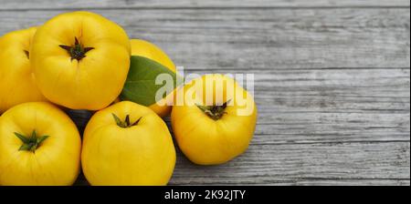 Reife gelbe Quitten-Früchte auf Holzhintergrund mit Kopierraum, Draufsicht. Das Konzept der organischen Gartenarbeit. Stockfoto