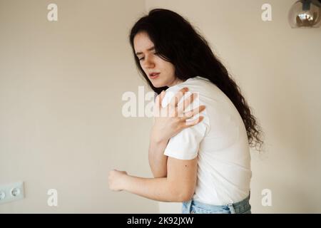 Schulterverletzung. Schönes Mädchen mit Schmerzen und Blutergüssen in ihrem Arm aufgrund eines Unfalls. Traumatologie Stockfoto