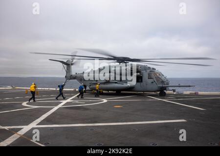 PAZIFISCHER OZEAN (6. Juli 2022) - Matrosen bereiten sich darauf vor, einen US Marine Corps CH-53E Super Hengst mit Marine Medium Tiltrotor Squadron (VMM) 362 (verstärkt) auf dem Flugdeck an Bord des Amphibientransportsdocks USS Anchorage (LPD 23), Juli 6, zu binden. Die Fähigkeit, nahtlos und gleichzeitig auf dem Meer, an Land und in der Luft zu arbeiten, stellt den einzigartigen Wert der amphibischen Fähigkeiten des Navy-Marine-Corps-Teams dar. Marineinfanteristen und Segler der Marine Expeditionary Unit (MEU) von 13. und der Makin Island Amphibious Ready Group (ARG) führen derzeit integrierte Trainingseinheiten in U durch Stockfoto