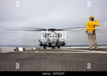 PAZIFIK (6. Juli 2022) - Mate Malcolm Butler von Chief Aviation Boatswain leitet am 6. Juli einen US Marine Corps CH-53E Superhengst mit Marine Medium Tiltrotor Squadron (VMM) 362 (verstärkt) auf dem Flugdeck an Bord des Amphibientransportsdocks USS Anchorage (LPD 23). Die Fähigkeit, nahtlos und gleichzeitig auf dem Meer, an Land und in der Luft zu arbeiten, stellt den einzigartigen Wert der amphibischen Fähigkeiten des Navy-Marine-Corps-Teams dar. Marineinfanteristen und Segler der Marine Expeditionary Unit (MEU) von 13. und der Makin Island Amphibious Ready Group (ARG) führen derzeit Integrat durch Stockfoto