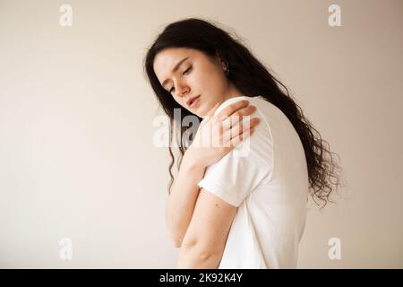 Schulterverletzung. Schönes Mädchen mit Schmerzen und Blutergüssen in ihrem Arm aufgrund eines Unfalls. Traumatologie Stockfoto