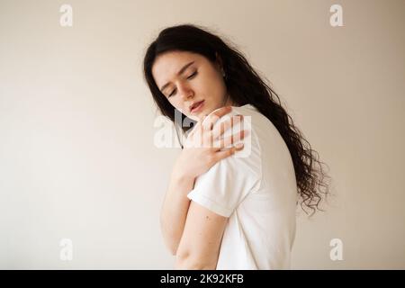 Schulterverletzung. Schönes Mädchen mit Schmerzen und Blutergüssen in ihrem Arm aufgrund eines Unfalls. Traumatologie Stockfoto