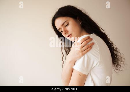 Schulterverletzung. Schönes Mädchen mit Schmerzen und Blutergüssen in ihrem Arm aufgrund eines Unfalls. Traumatologie Stockfoto