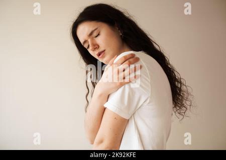 Schulterverletzung. Schönes Mädchen mit Schmerzen und Blutergüssen in ihrem Arm aufgrund eines Unfalls. Traumatologie Stockfoto