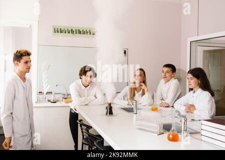 Vulkanexperiment. Die Chemielehrerin der Schule zeigt den Kindern Experimente im Labor. Bildungskonzept. Gruppenunterricht von Klassenkameraden in Chemie Stockfoto