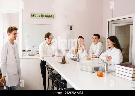 Vulkanexperiment. Die Chemielehrerin der Schule zeigt den Kindern Experimente im Labor. Bildungskonzept. Gruppenunterricht von Klassenkameraden in Chemie Stockfoto