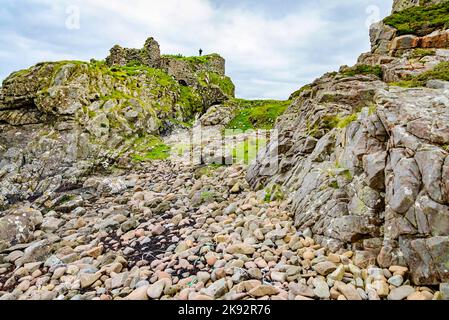 Mit Blick auf die Meere von Loch Slapin, im Hochsommer bleibt das schottische Schloss erhalten, das auf viele lose Felsen und Kieselsteine herabblickt. Stockfoto