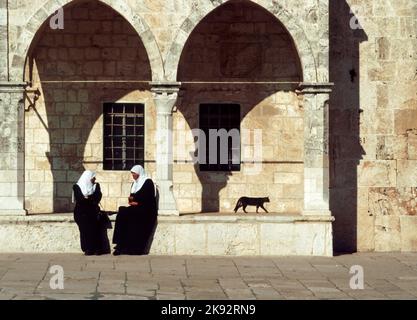 Jerusalem, Israel - 1. Januar 1994: arabische Frauen sitzen an der Mauer des Tempelbereichs in Jerusalem. Jerusalem ist eine heilige Stadt für die drei großen Abrahamitischen Stockfoto