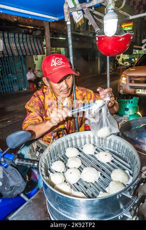 BANGKOK, THAILAND - 23. DEZ 2009: Man verkauft leckere Knödel auf dem Outdoor-Markt in Bangkok, Thailand. Der Markt Pak Klong Thalat ist einer der Stockfoto