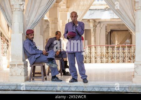 UDAIPUR, INDIEN - Okt 21, 2012: Wache sitzt auf einem Holzstuhl im Stadtpalast in Udaipur, Indien. Der Grundstein der Festung wurde 1559 von Udai gelegt Stockfoto