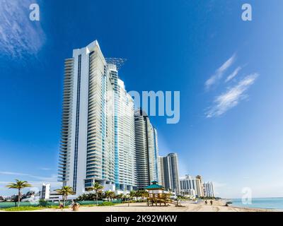 SUNNY ISLES BEACH, USA - 28. JULI 2013: Die Menschen entspannen sich in der Nähe der Pier in Sunny Isles Beach, USA. 1936 baute der Milwaukee-Malzmagnat Kurtis Sunny Isles Stockfoto