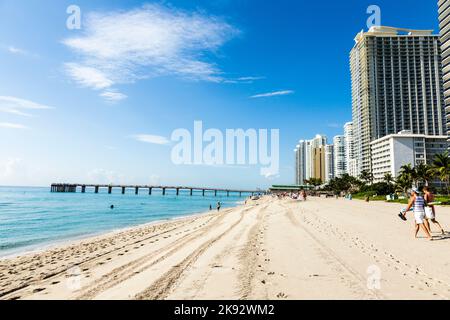 SUNNY ISLES BEACH, USA - 28. JULI 2013: Die Menschen entspannen sich in der Nähe der Pier in Sunny Isles Beach, USA. 1936 baute der Milwaukee-Malzmagnat Kurtis Sunny Isles Stockfoto