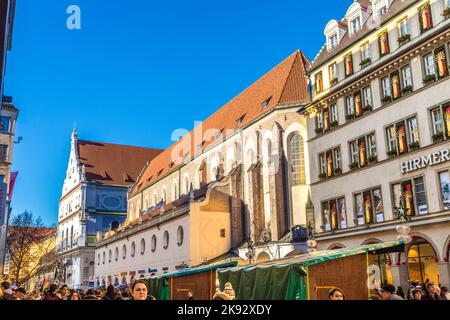 MÜNCHEN, DEUTSCHLAND - 27. DEZ 2013: Die Menschen gehen einkaufen. Außenansicht von Hirmer, dem größten Herrenmodehaus der Welt, mit Dekoration in München, Stockfoto