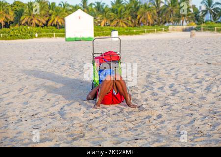 MIAMI, USA - 20. AUG 2014: Am späten Nachmittag entspannt sich der Mann am Strand in Miami, USA. South Beach ist der berühmteste Strand in florida. Stockfoto