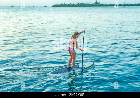 KEY WEST, USA - 26. AUG 2014: Frau genießt Stand Up Paddle Surfen in Key West. Die Küstenkulturen haben sich in Kanus erhoben und standen dafür Stockfoto