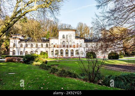 BAD SODEN - DEUTSCHLAND - 11. JAN 2015: Historisches Badehaus mit malerischem Park in Bad Soden, Deutschland. Das Badehaus wurde 1870 von Dr. Georg Thilenius erbaut. Stockfoto