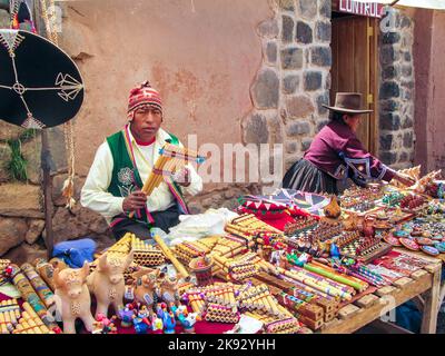 RAQCHI, PERU - 19. JANUAR 2015: Die Menschen besuchen den berühmten traditionellen Markt in Raqchi, Peru. Der Markt bietet lokalen Kunsthandwerk und Souvenirs für Touristen Stockfoto