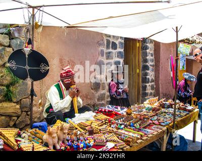 RAQCHI, PERU - 19. JANUAR 2015: Die Menschen besuchen den berühmten traditionellen Markt in Raqchi, Peru. Der Markt bietet lokalen Kunsthandwerk und Souvenirs für Touristen Stockfoto