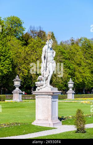 MÜNCHEN, DEUTSCHLAND - 20. April 2015: Statue Grand Parterre (Barockgarten) und Rückansicht des Schlosses Nymphenburg. München, Bayern, Deutschland Stockfoto