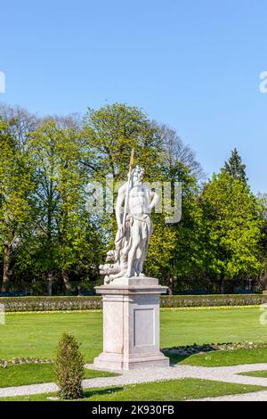 MÜNCHEN, 20. April 2015: Neptun-Statue im Barockgarten und Rückansicht des Schlosses Nymphenburg. München, Bayern, Deutschland Stockfoto