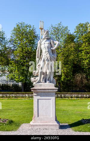 MÜNCHEN, 20. April 2015: Neptun-Statue im Barockgarten und Rückansicht des Schlosses Nymphenburg. München, Bayern, Deutschland Stockfoto