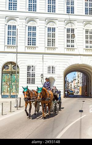 Wien, Österreich - 24. April 2015: Innenstadt Blick auf die Straße, Menschen zu Fuß und Fiaker mit weißen Pferden in Wien, Österreich Stockfoto