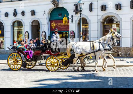 Wien, Österreich - 24. April 2015: Innenstadt Blick auf die Straße, Menschen zu Fuß und Fiaker mit weißen Pferden in Wien, Österreich Stockfoto