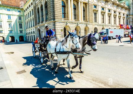 Wien, Österreich - 24. April 2015: Innenstadt Blick auf die Straße, Menschen zu Fuß und Fiaker mit weißen Pferden in Wien, Österreich Stockfoto