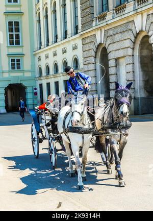 Wien, Österreich - 24. April 2015: Innenstadt Blick auf die Straße, Menschen zu Fuß und Fiaker mit weißen Pferden in Wien, Österreich Stockfoto