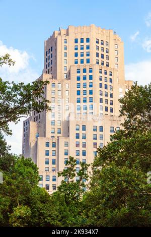 NEW YORK, USA - 11. JULI 2010: Hohe alte Backsteingebäude in New York, Manhattan. Gebäude am Nachmittag mit eiserner Statue des Menschen auf dem Dach in New Y Stockfoto