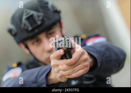 Studenten-Kadetten der Serbischen Polizeiakademie trainieren in grundlegenden Polizei-/Strafverfolgungsmethoden mit Handfeuerwaffen und verhaften einen Verdächtigen Stockfoto