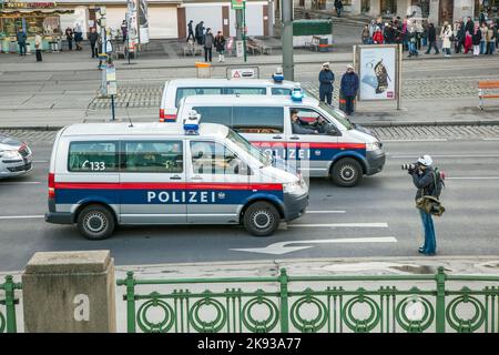 WIEN, ÖSTERREICH - 27. NOVEMBER 2010: Polizei und Fotograf an der Spitze der friedlichen Demonstration gegen die Kürzung von Sozialaufwenden durch den Bundesrat Stockfoto