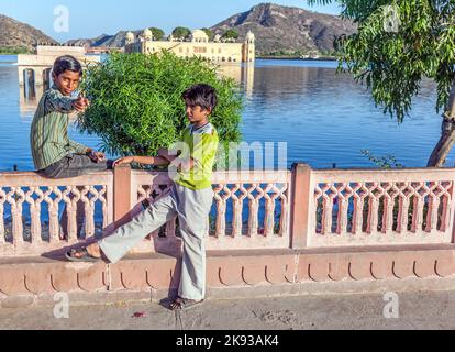 JAIPUR, INDIEN - NOVEMBER 12, 2011 : Jugendliche genießen den Sonnenuntergang am Wasserpalast in Jaipur, Indien. Der Palast (Jal Mahal) in man Sagar See wurde in gebaut Stockfoto