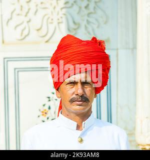 JAIPUR, INDIEN - 19. OKTOBER 2012: Begrüßung durch nicht identifizierte Wache in typisch indischem Kleid des Großen Palastes in Jaipur, Rajasthan, Indien Stockfoto