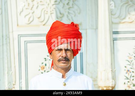 JAIPUR, INDIEN - 19. OKTOBER 2012: Begrüßung durch nicht identifizierte Wache in typisch indischem Kleid des Großen Palastes in Jaipur, Rajasthan, Indien Stockfoto