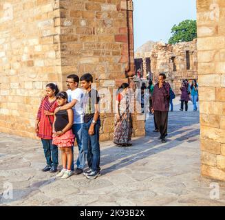 DELHI, INDIEN - 27. MÄRZ 2012: Nicht identifizierte Touristen gehen durch den Qutub Minar Komplex in Delhi, Indien. Qutub Minar ist der höchste Minar in Indien, Origi Stockfoto