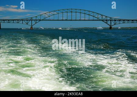 Die Spur eines Bootes in der Bucht zieht sich von der Stahlbogenbrücke des Robert Moses Causeway auf Long Island ab Stockfoto