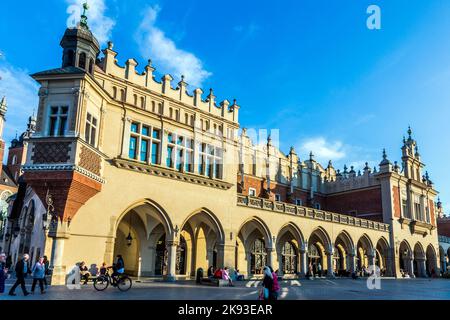 KRAKAU, POLEN - 7. Okt 2014: Menschen auf dem Hauptmarkt in der Nähe von Sukiennice, Tuchhalle und Rathausturm. Der Tuchsaal wurde im 14. Jahrhundert erbaut Stockfoto