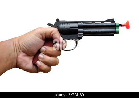 Hand hält Spielzeugpistole auf weißem Hintergrund selektiver Fokus Stockfoto