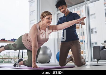 Eine gute Gesundheit ist nie ein zu langer Weg. Ganzkörperaufnahme einer reifen Frau, die mit ihrem Physiotherapeuten Rehabilitations- und Bewegungsübungen macht Stockfoto